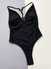 Black one-piece swimsuit with plunging neckline and ring detail.