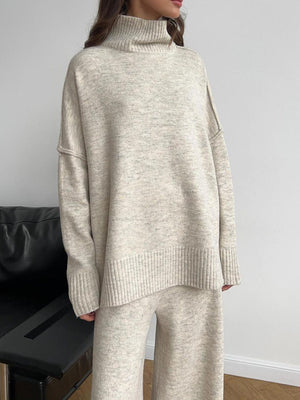 Oversized beige turtleneck lounge set with wide-leg pants and ribbed cuffs and hem.