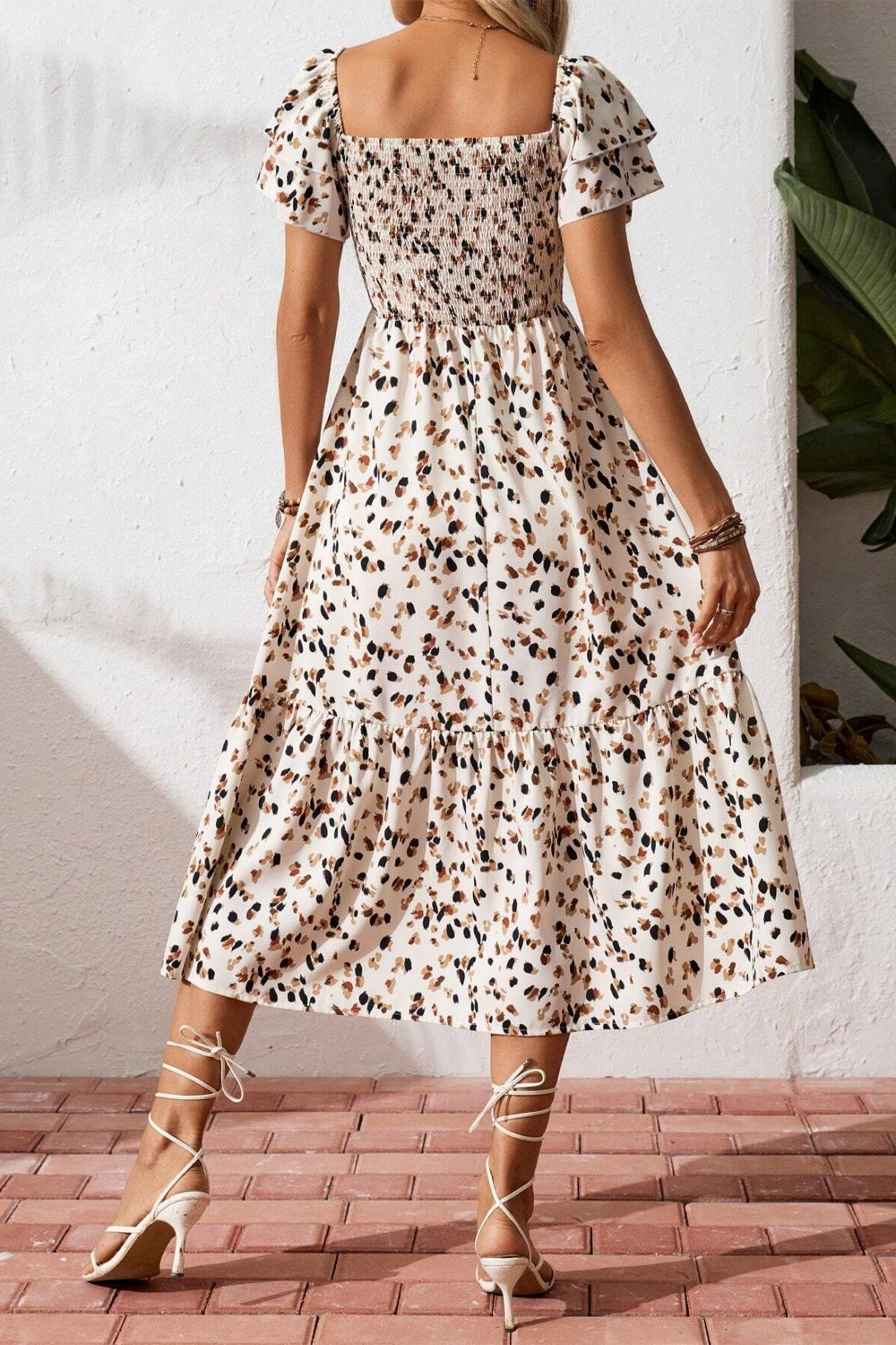 Tiered ruffle sleeve midi dress with abstract print, smocked bodice, and tiered skirt.