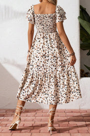 Tiered ruffle sleeve midi dress with abstract print, smocked bodice, and tiered skirt.