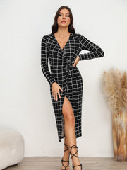 Black grid wrap midi dress with V-neck, long sleeves, and a thigh-high slit.