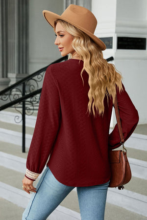 Burgundy textured V-neck blouse with lace cuff detail