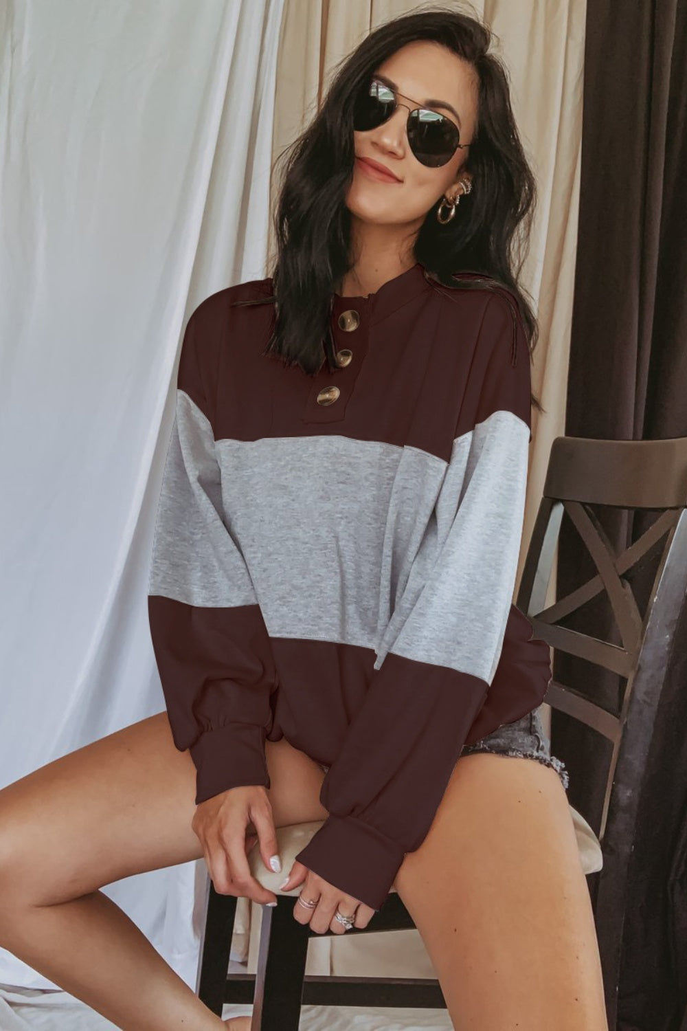 Colorblock sweatshirt with balloon sleeves and button neckline in gray and maroon.
