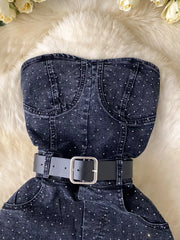 Black denim romper with rhinestone embellishments and a black belt.