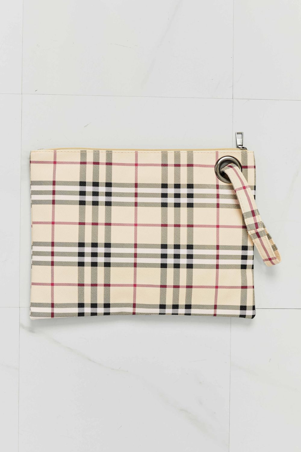 Plaid print wristlet clutch bag in cream/black with grommet detail and wrist strap.