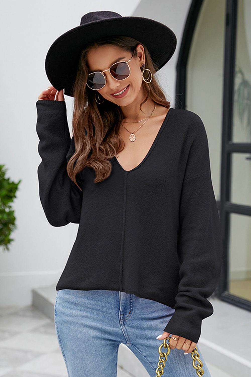 Black textured knit pullover sweater with deep V-neck and long sleeves.