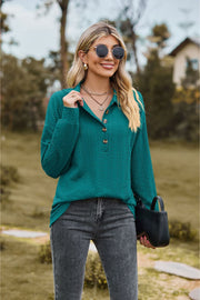 Turquoise textured knit polo shirt with button detail and collared neckline.