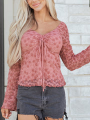 Knot-detail floral lace blouse in rose with ruched neckline and long sleeves.