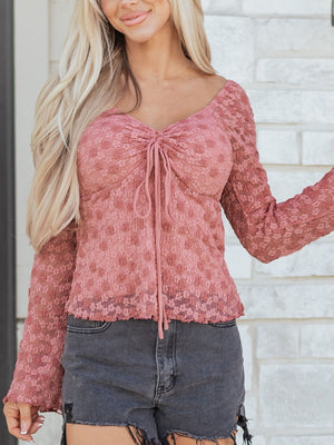 Knot-detail floral lace blouse in rose with ruched neckline and long sleeves.
