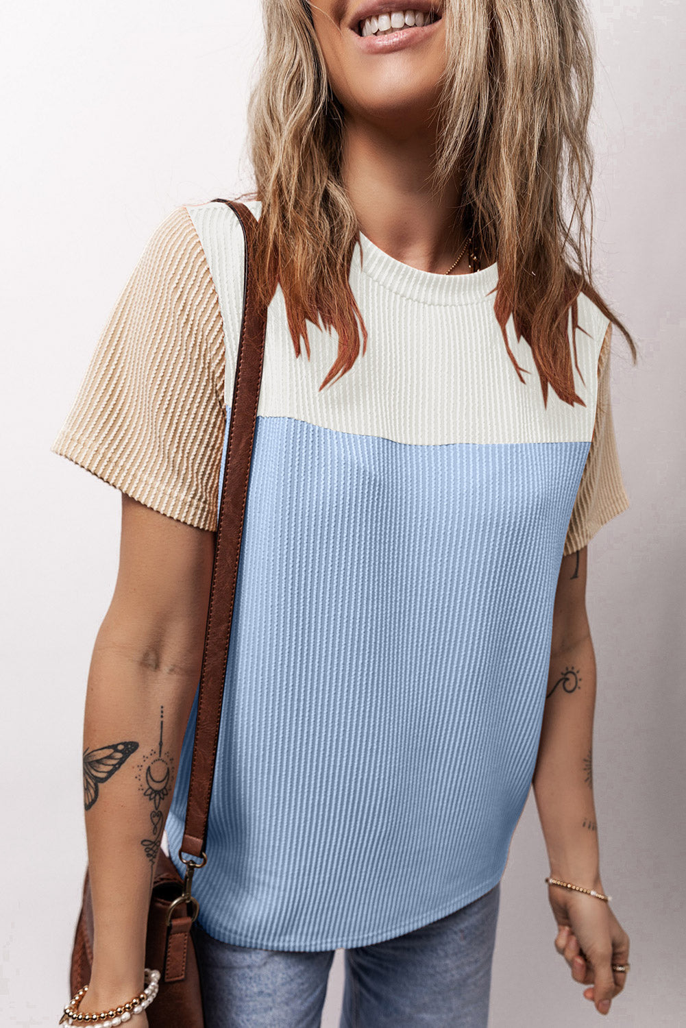 Panelled ribbed tee in light blue and white with textured tan sleeves.