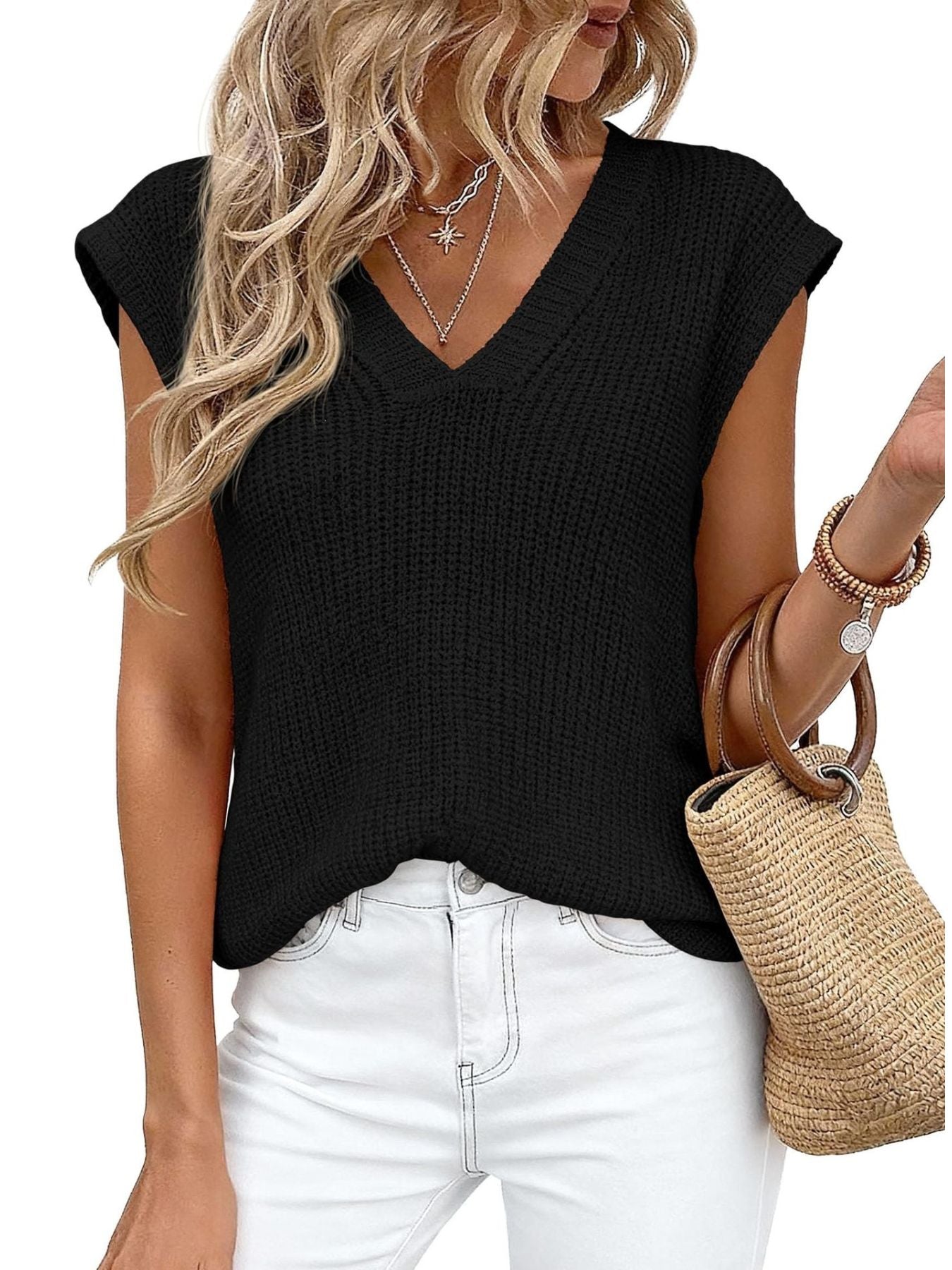 Textured black V-neck sweater vest with short sleeves, styled with white jeans and a straw bag.