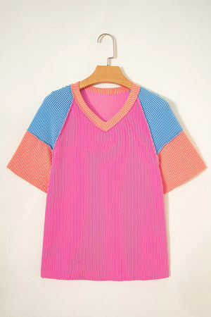 Vibrant ribbed V-neck t-shirt with color block sleeves in pink, blue, and coral.