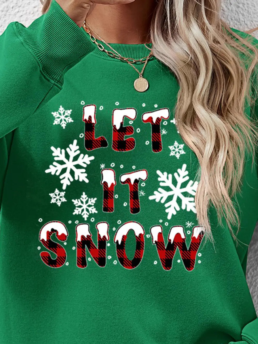 Green crewneck sweatshirt with "Let It Snow" graphic and snowflakes