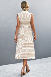 Sleeveless midi dress in white with geometric print, collared neckline, and belted waist.