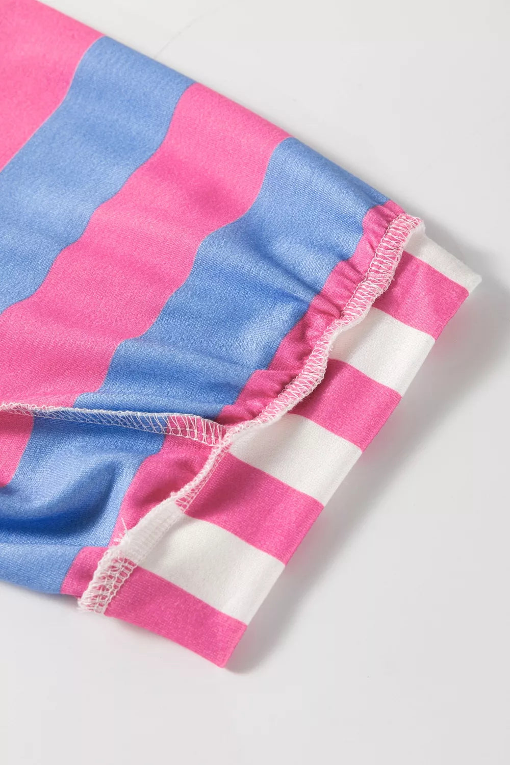 Overshirt with pink, blue, and white wavy stripes and ruffled sleeve hem detail.