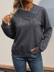 Dark gray cable knit sweater with asymmetric button-neck detail.