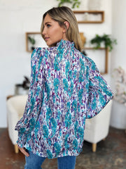 High neck abstract print blouse in blue and purple with long sleeves.