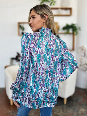 High neck abstract print blouse in blue and purple with long sleeves.
