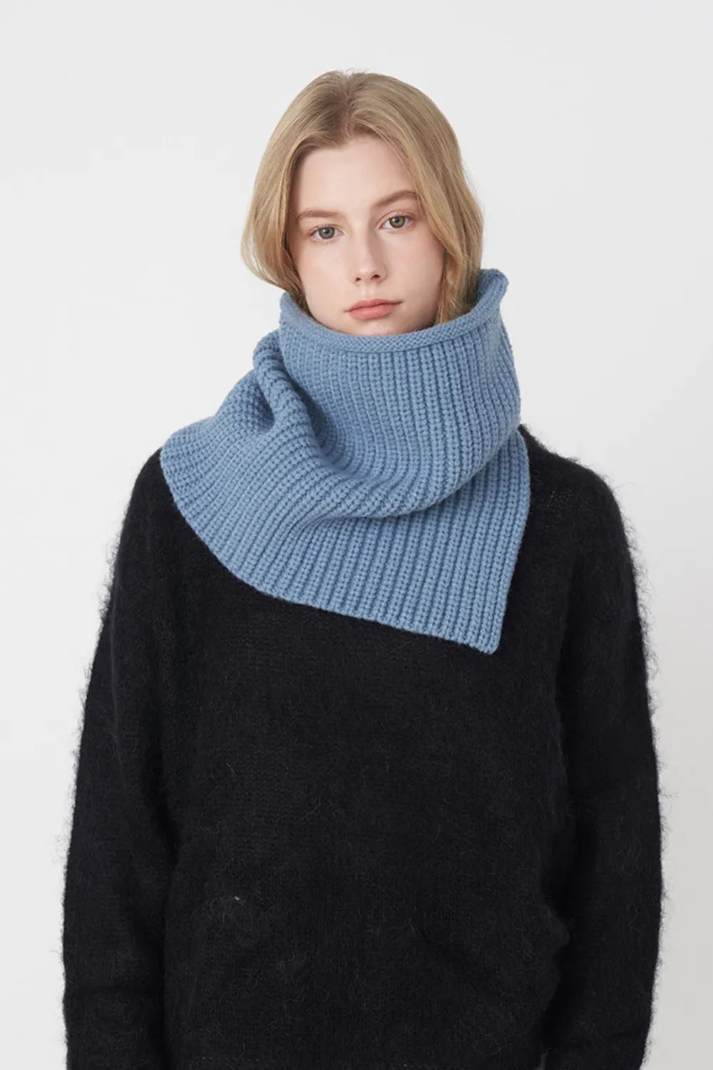 Ribbed neck warmer in sky blue with extended panel, worn by a model in a black sweater.