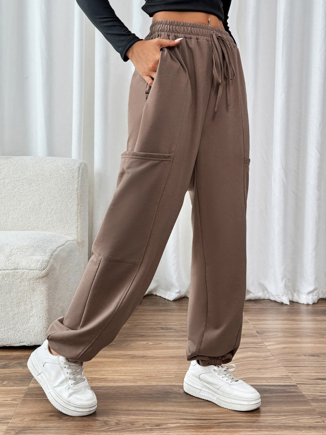 Taupe cargo joggers with drawstring waist and cuffed ankles.