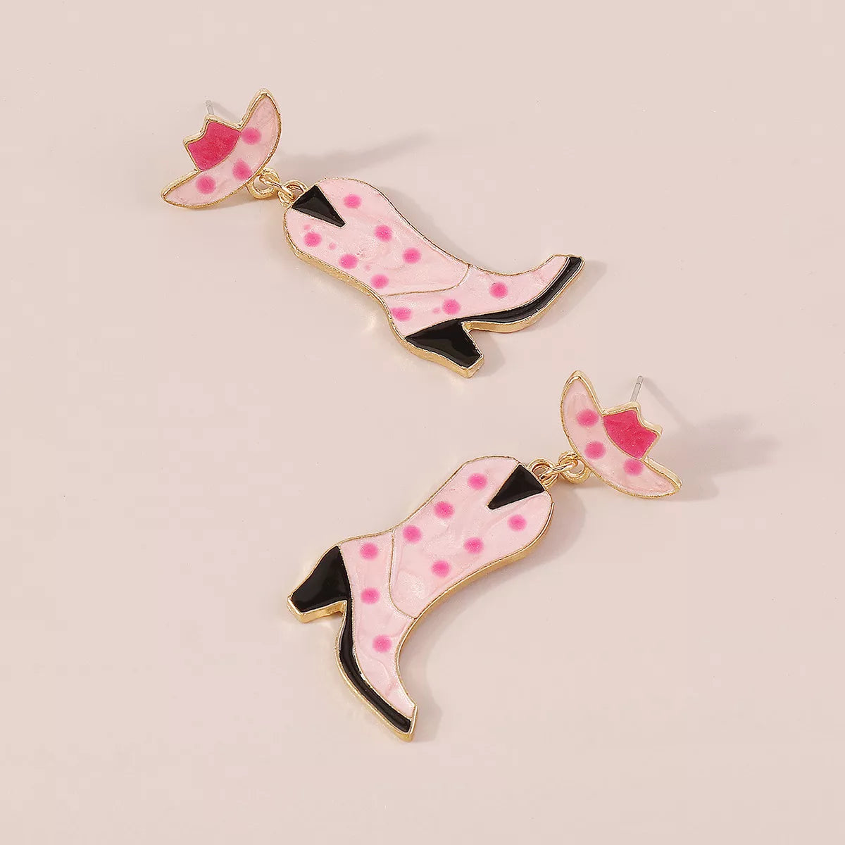 Pink cowboy boot dangle earrings with polka dots and a hat detail.