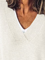 Relaxed ivory ribbed knit sweater with V-neck, layered over a white camisole.