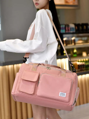 Pink Oxford cloth travel bag with multiple pockets and detachable strap.
