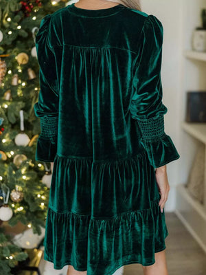Dark green velvet tiered mini dress with smocked cuffs and gathered yoke.