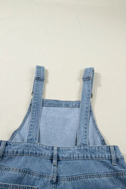 Light wash denim jumpsuit with adjustable straps and wide legs.