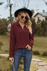 Burgundy textured cable knit polo top with a V-neck and long sleeves.