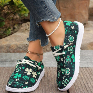 Clover print canvas slip-on sneakers with white decorative laces and white soles.