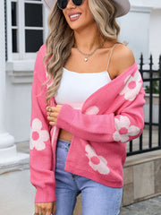Floral intarsia knit cardigan in blush pink acrylic with white flower pattern.
