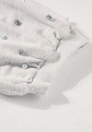 Light gray sweatshirt with pearl and rhinestone embellishments on puff sleeves and ribbed cuffs.