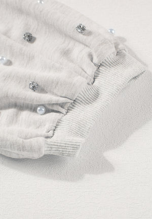 Light gray sweatshirt with pearl and rhinestone embellishments on puff sleeves and ribbed cuffs.