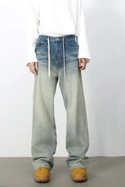 Faded wash wide-leg jeans with drawstring waist and light blue to pale green gradient.