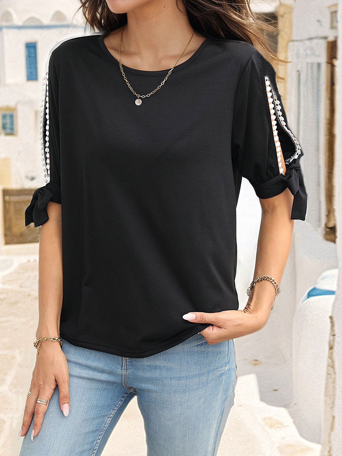 Black split sleeve blouse with lace trim and tie details, crew neck, short sleeves.