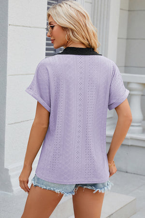 Lavender perforated panel polo top with black collar and cuffed short sleeves.