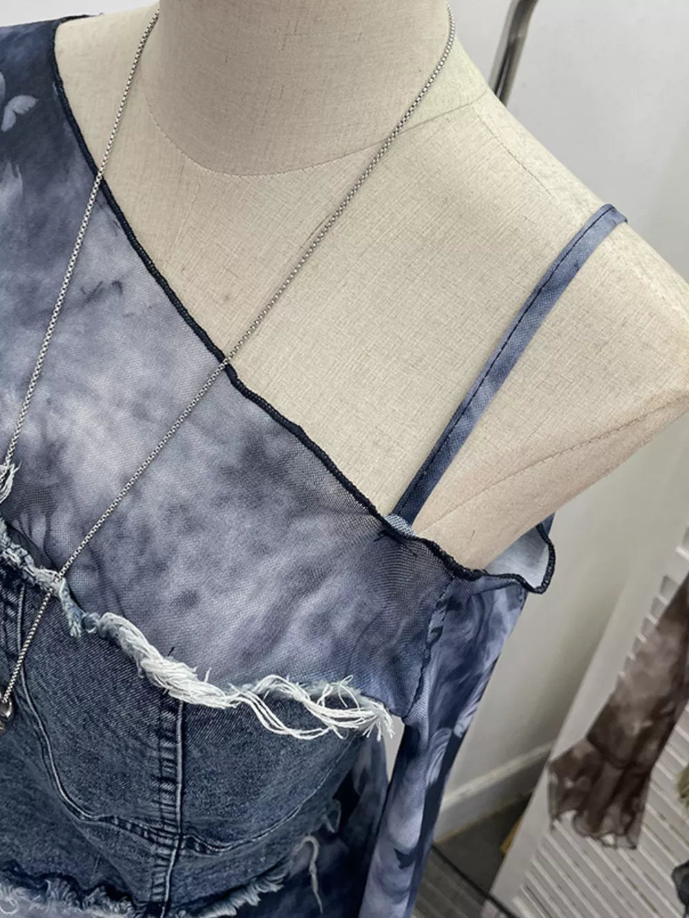 Edgy asymmetrical denim t-shirt in gray black with distressed details and a tie-dye print.
