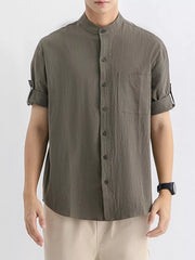 Men's relaxed fit button-up shirt in dark green with a chest pocket and rolled sleeves.