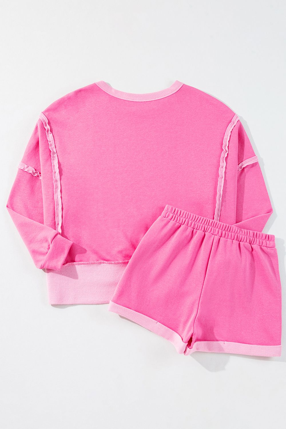 Pink loungewear set with ruffled seams and contrast trim.