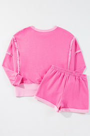 Pink loungewear set with ruffled seams and contrast trim.
