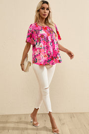 Hot pink floral smocked yoke flutter sleeve blouse with a relaxed fit.