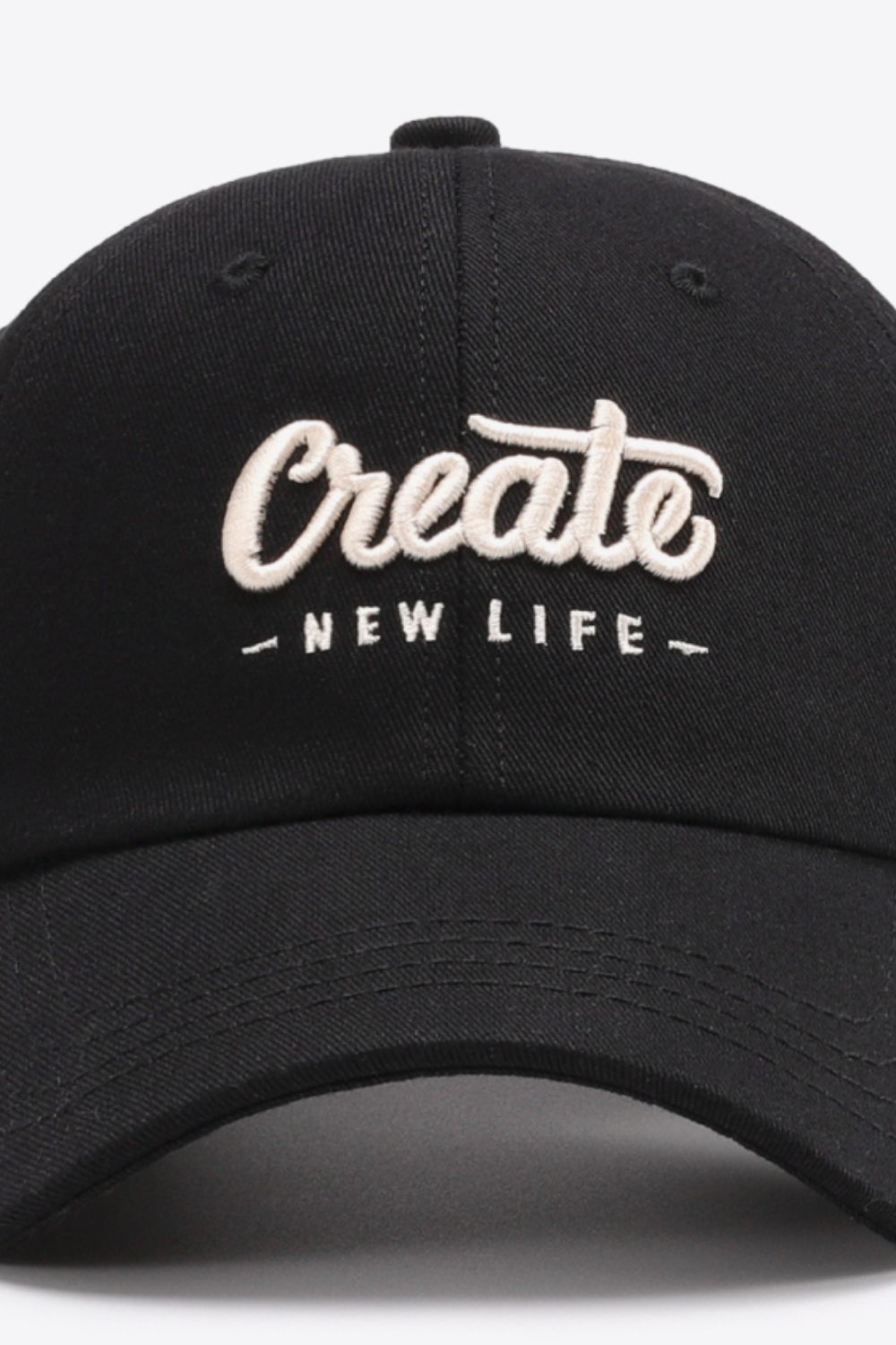 Black baseball cap with embroidered "Create New Life" text.