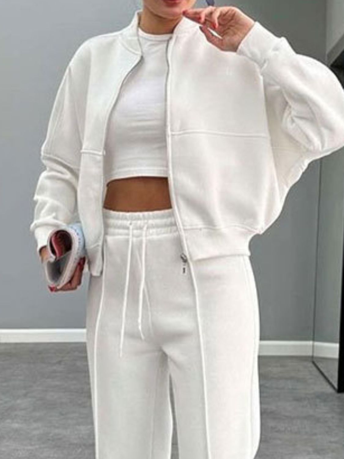 White bomber jacket and wide-leg tracksuit with drawstring waist and zip closure