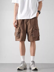 Brown cargo shorts with multiple zip and flap pockets, lightweight fabric.
