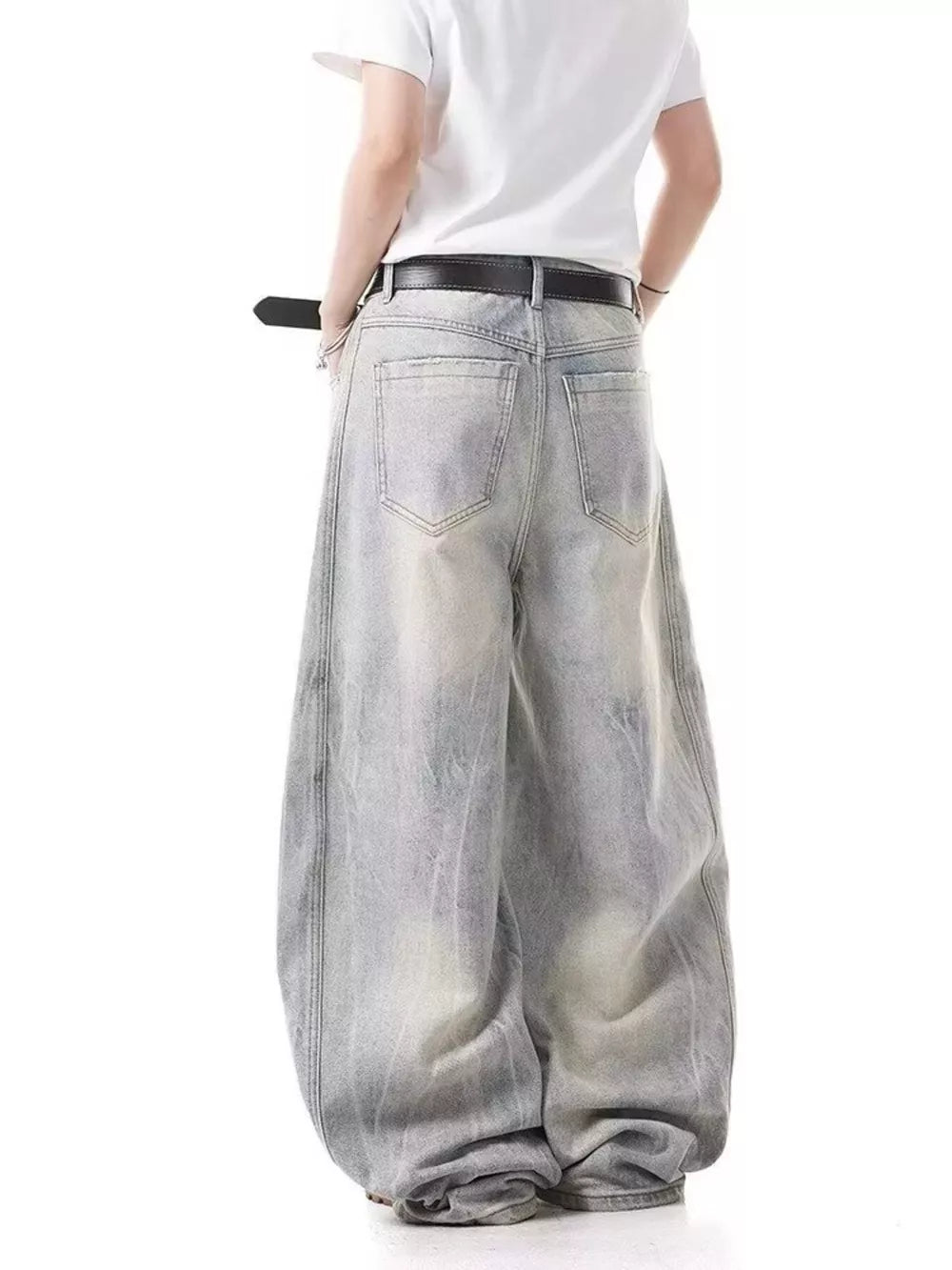 Men's light wash baggy jeans with a belted waist and distressed details.
