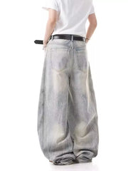 Men's light wash baggy jeans with a belted waist and distressed details.