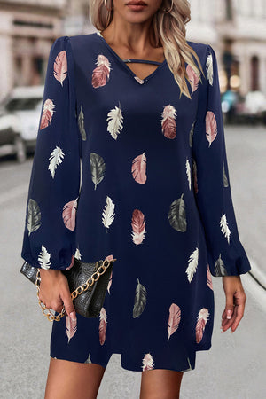 Navy feather print mini dress with cutout neckline and long sleeves.