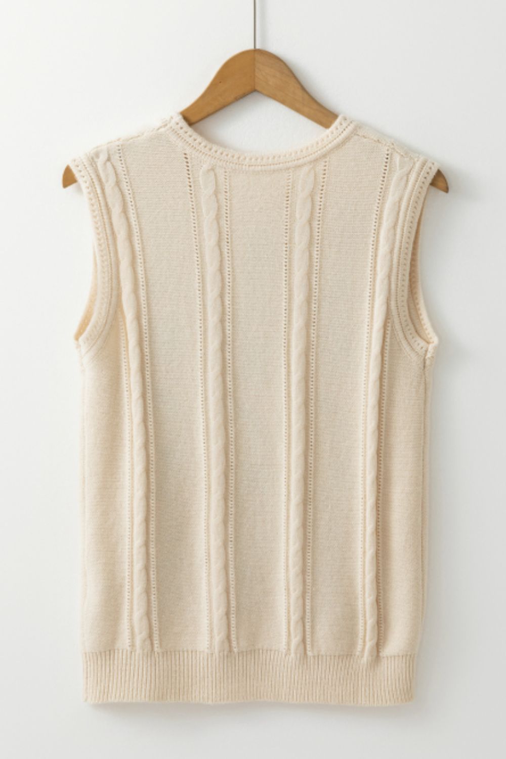 Beige cable knit vest with vertical cable detailing and a crew neckline.