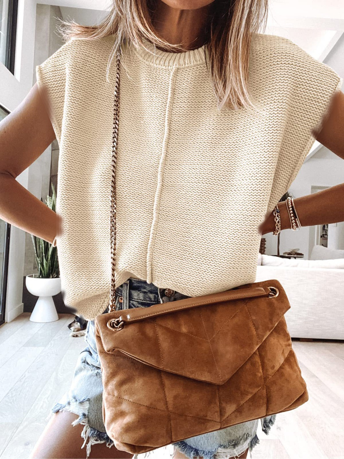 Ivory knit tank top with center seam and crew neck, styled with denim shorts and a brown suede purse.